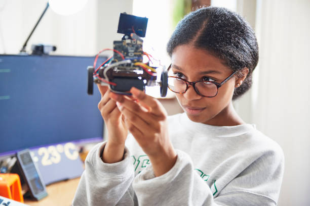 teenage girl in house building robot / Female Focus Collection