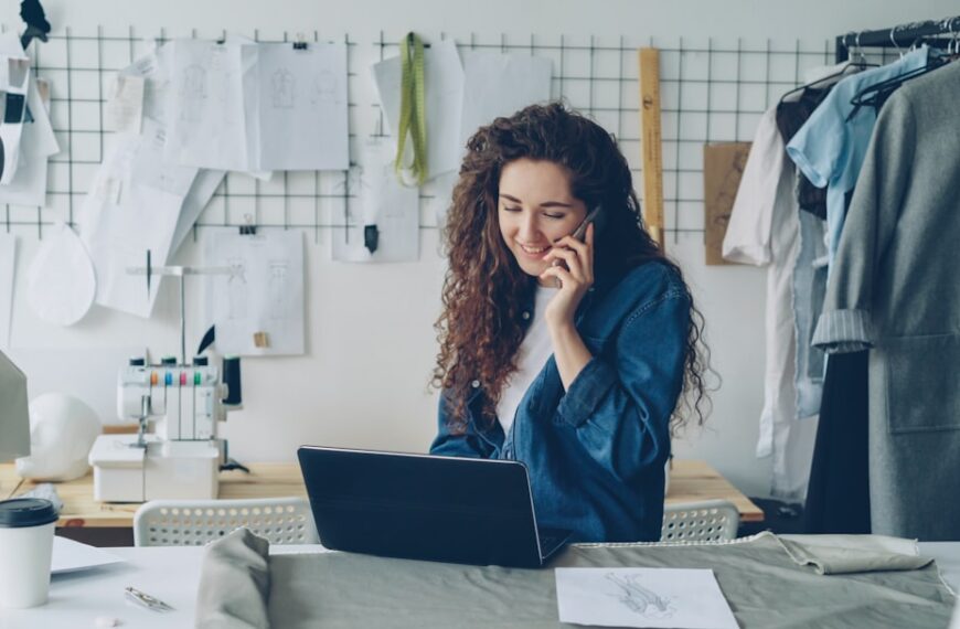 Fashion designer on the phone, working on a laptop