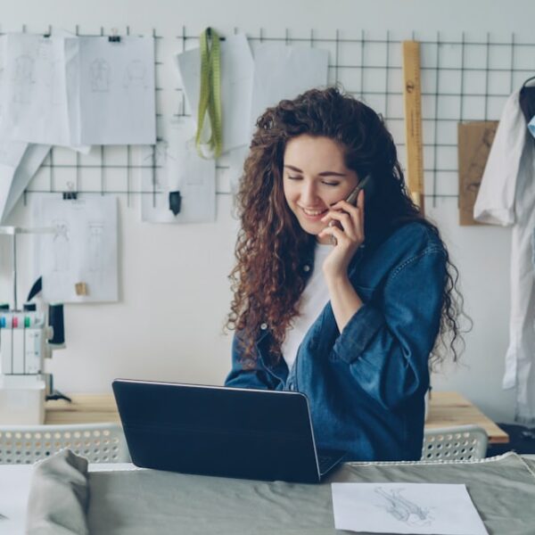 Fashion designer on the phone, working on a laptop